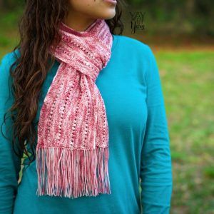 Girl outdoors wearing a blue long sleeves and a wild rose scarf wrapped around the neck