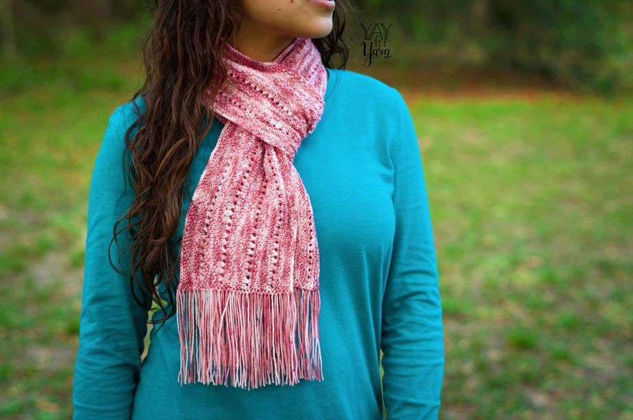 Girl outdoors wearing a blue long sleeves and a wild rose scarf wrapped around the neck