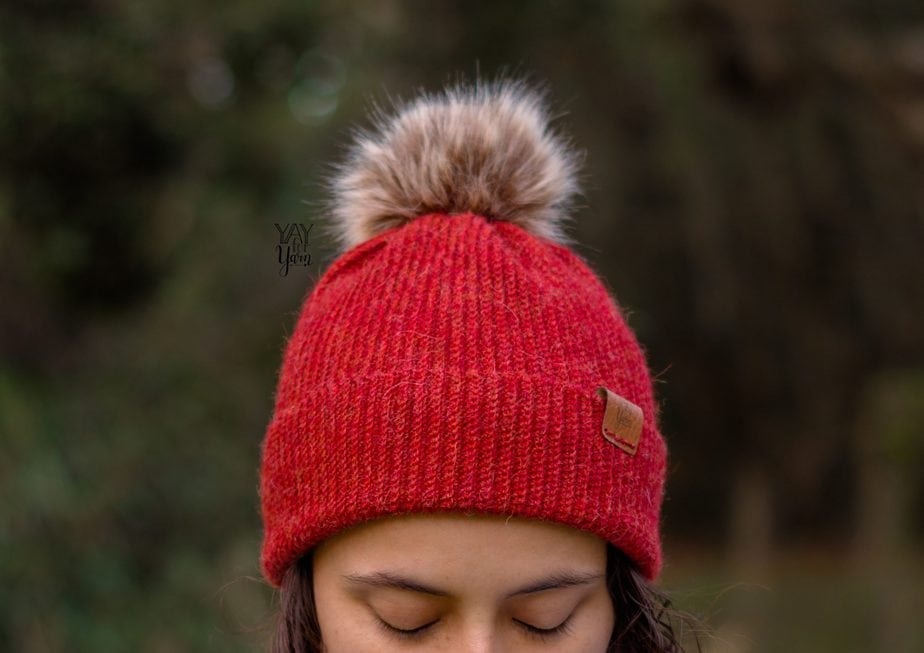 red fingering weight crochet hat with brown faux fur pom pom