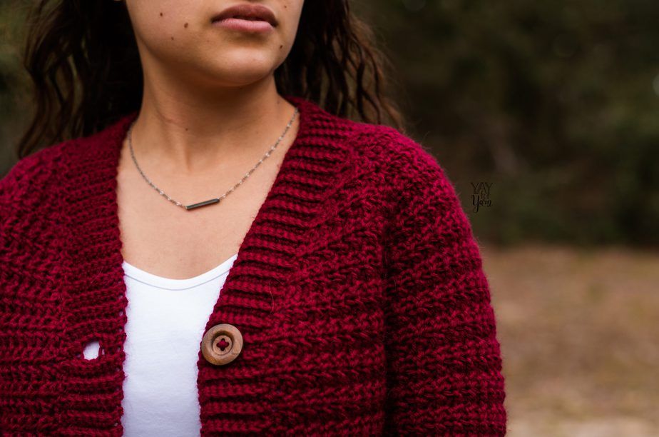 closeup of button band - woman wearing crimson red crochet cardigan with buttons