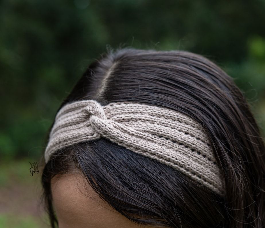 close-up of a girl wearing a twisted knit headband with eyelets