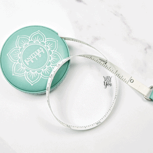 teal, vegan leather covered retractable measuring tape on white marble background