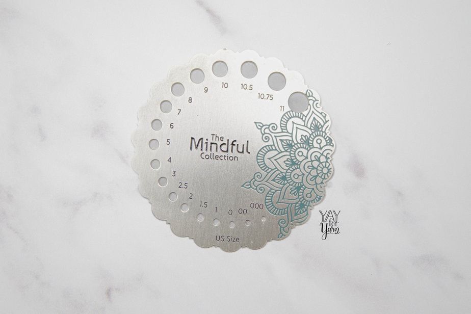 sterling silver plated needle gauge for checking needle size on white marble