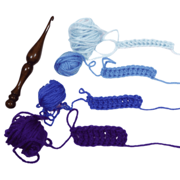 A crochet hook and four yarns with colors ranging from deep blue to light blue in a white background